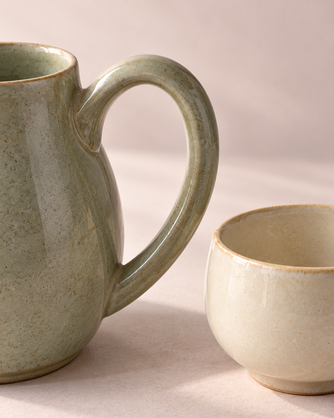 Reed pitcher handle and ivory Dawn cup rim in a quiet ceramic detail study